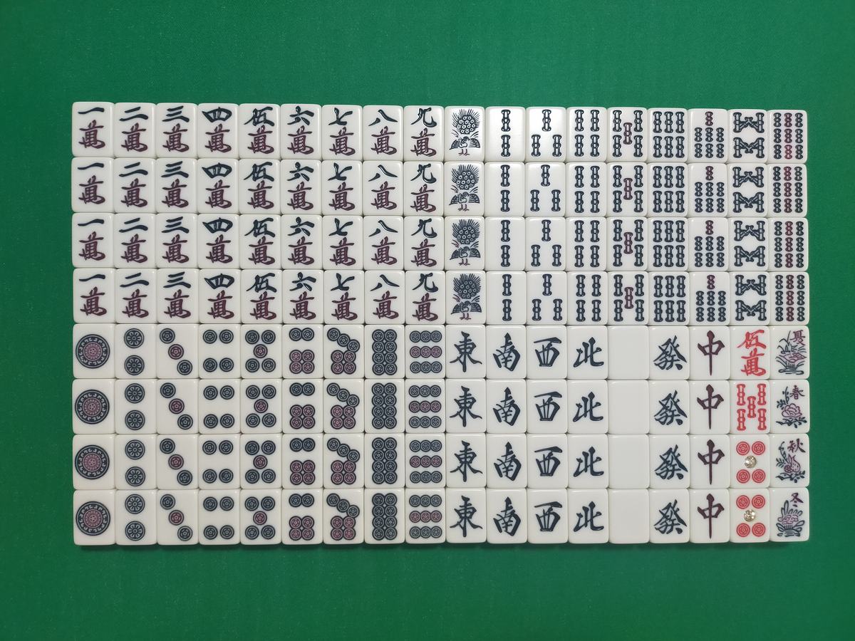 A full set of mahjong tiles laid out in rows by suit, with winds and dragons